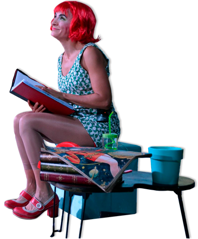 Maité sentada con libro en el espectáculo ALONE
